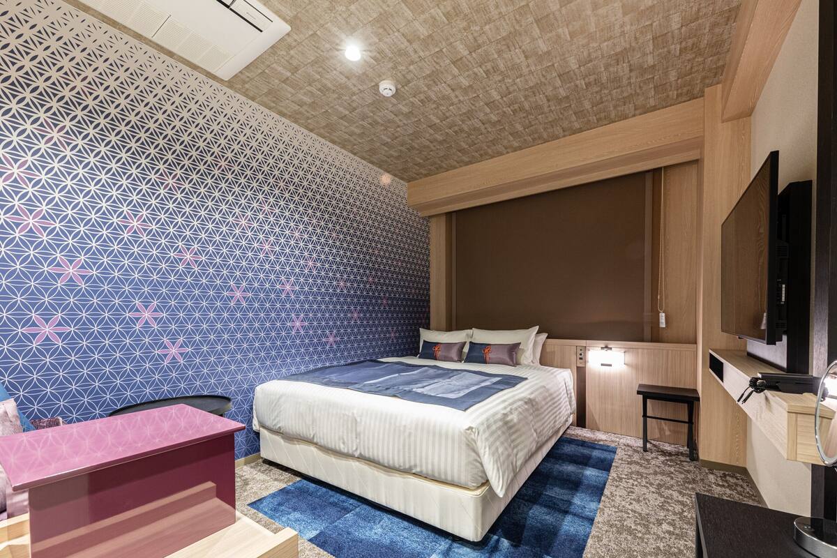 Ein Schlafzimmer mit Bett, Nachttisch und Fernseher.