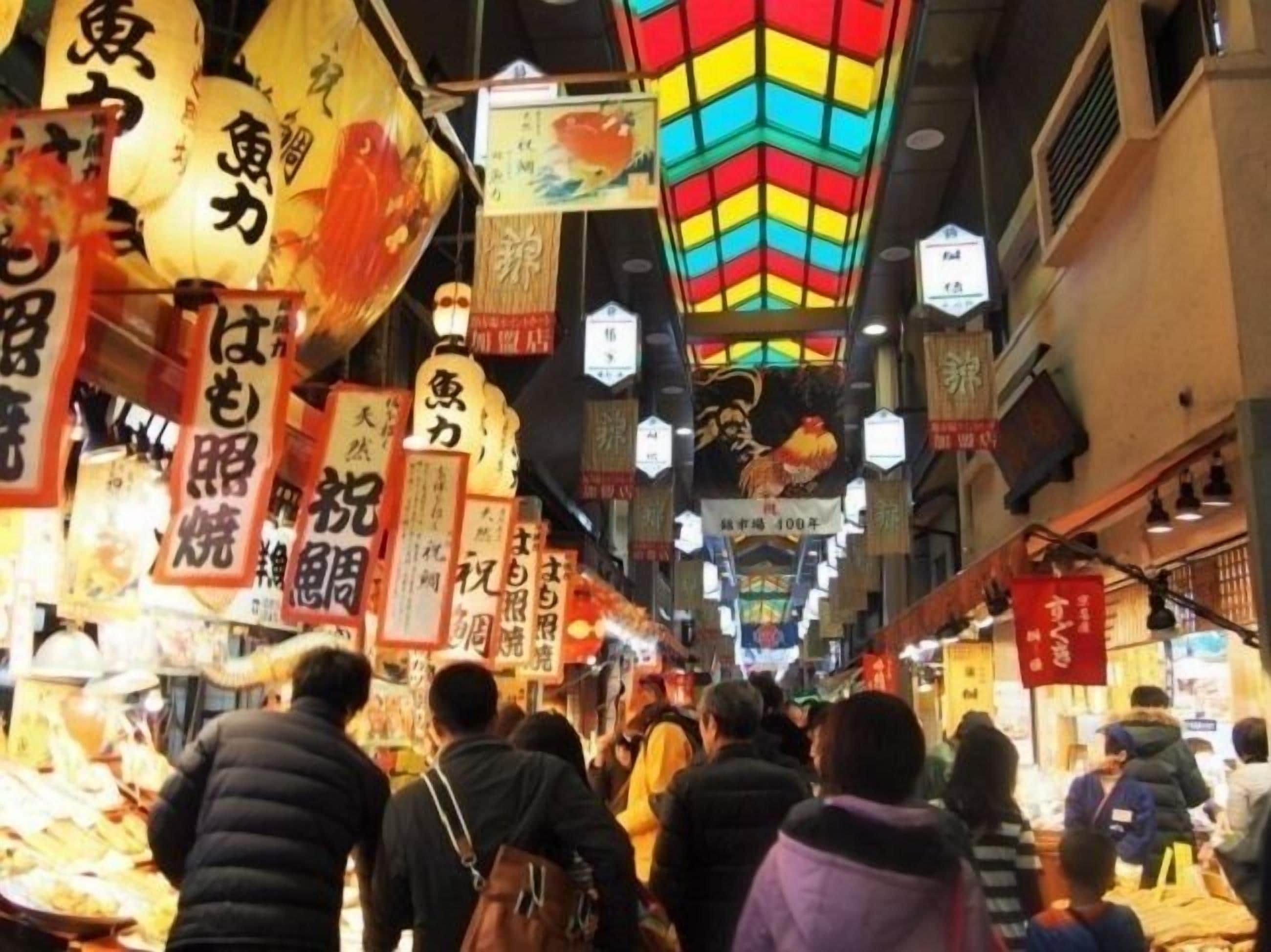 A crowded market with people browsing stalls.