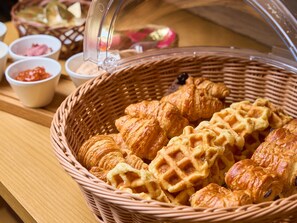 A basket of assorted pastries including croissants and waffles, accompanied by small bowls of condiments. - Hotel Musse Kyoto Shijo Kawaramachi Meitetsu (Kyoto)