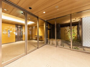 A modern interior with glass walls, a wooden ceiling, and a tiled floor. - Hotel Musse Kyoto Shijo Kawaramachi Meitetsu (Kyoto)