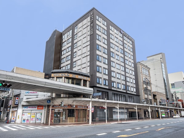 A multi-story hotel with a modern facade, a covered entrance, and various commercial establishments on the ground floor. - Hotel Musse Kyoto Shijo Kawaramachi Meitetsu (Kyoto)