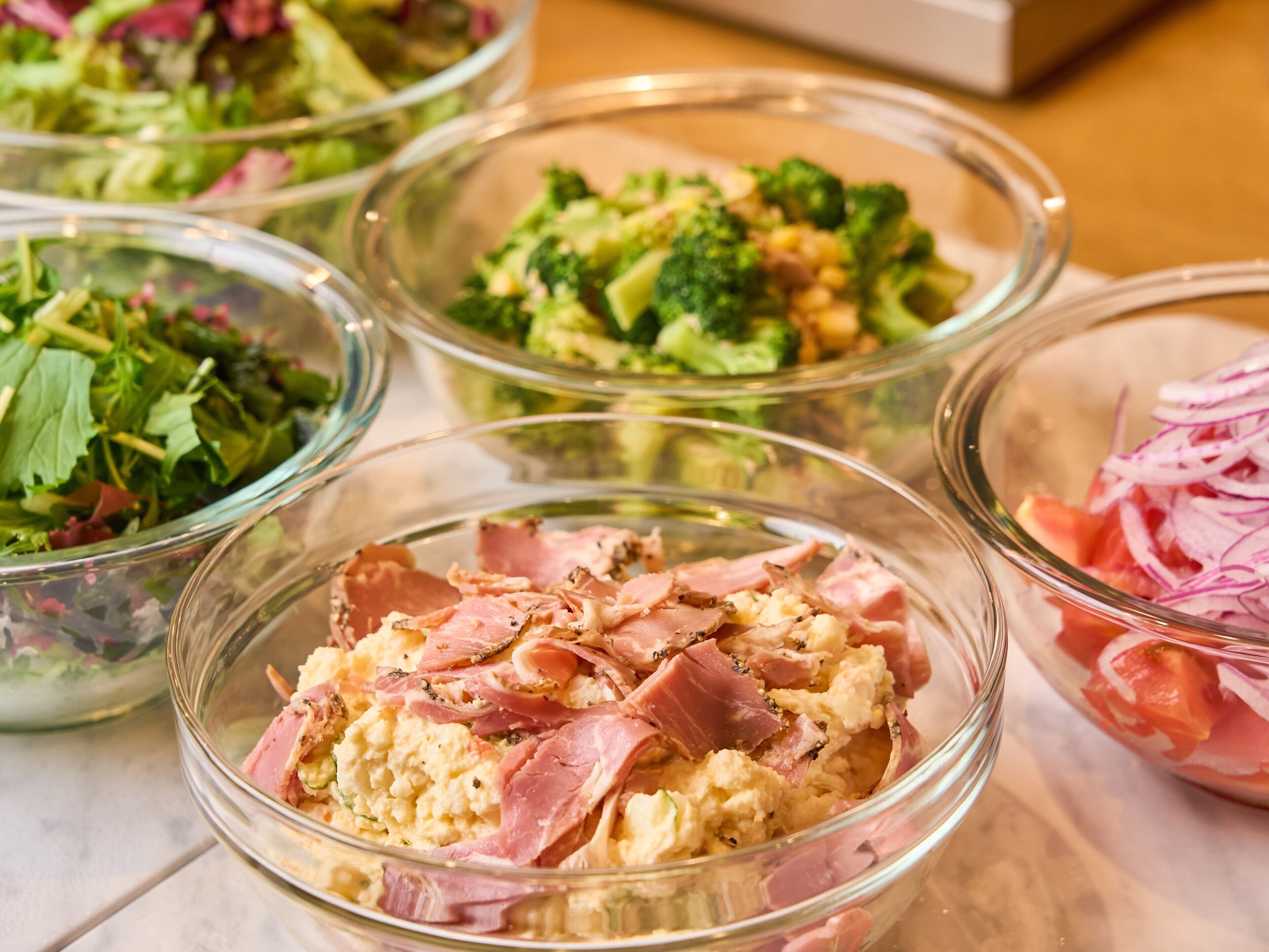 A variety of food dishes in clear glass bowls on a table.