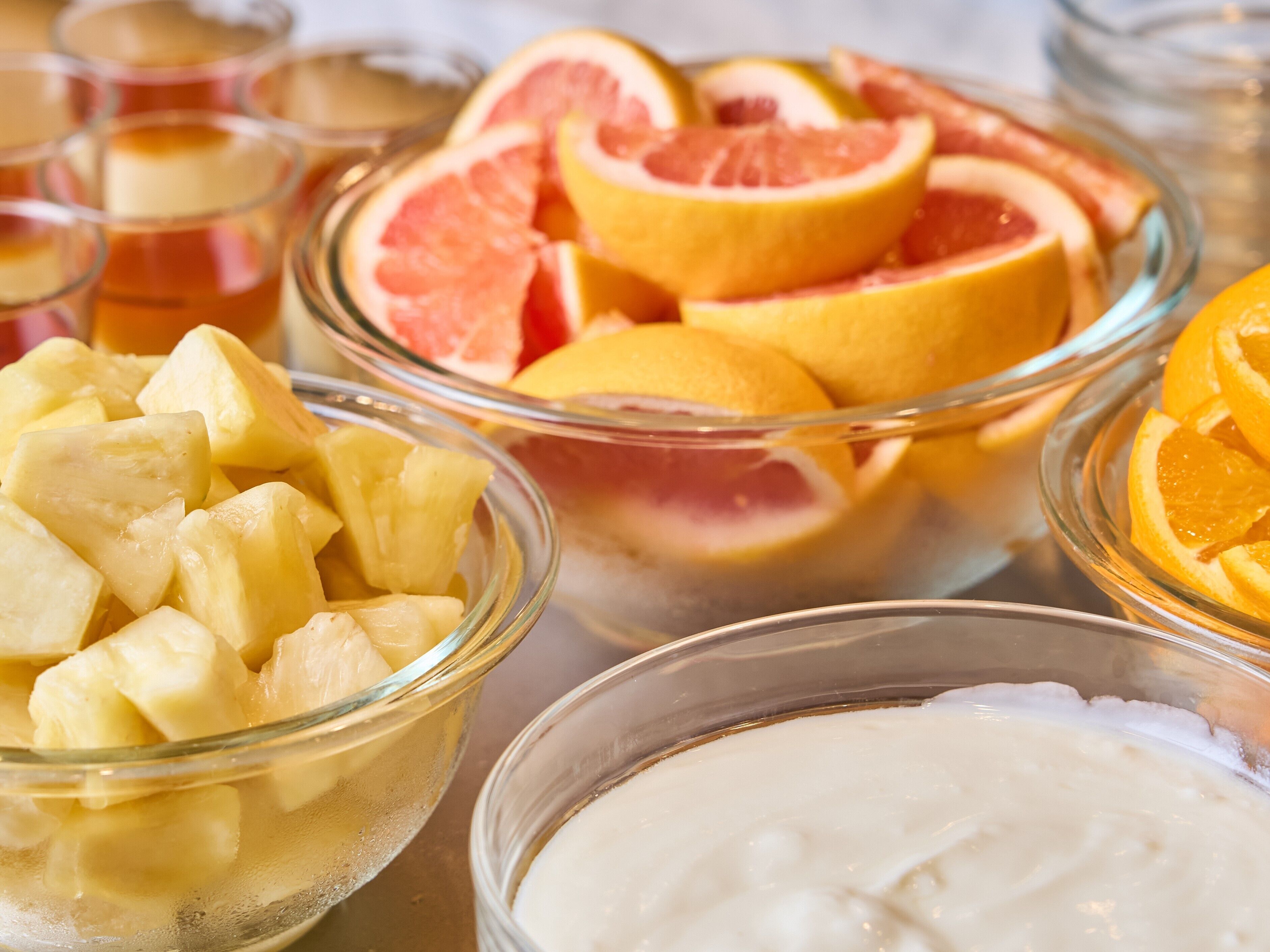 Tazones de fruta con piña, pomelo y rodajas de naranja.