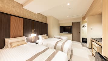 A hotel room with two beds, a desk, a TV, and a minibar.