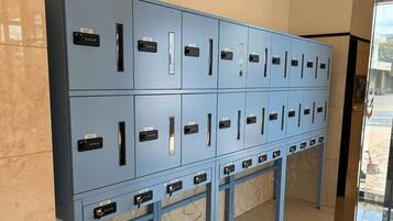 A row of blue lockers with numbered labels, indicating a secure storage area, possibly for guests' belongings.