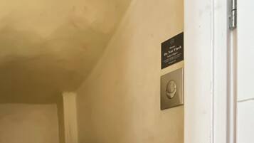Un bagno piccolo con il water, uno scaffale con un asciugamano e il cartello 'Non gettare'.