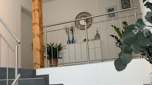 A staircase with a wooden column, metal railing, and potted plants. - Ferien auf Rüdlins Winzerhof (Auggen)