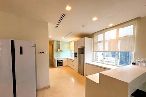 Una cocina moderna con horno empotrado, refrigerador y ventana con vistas.