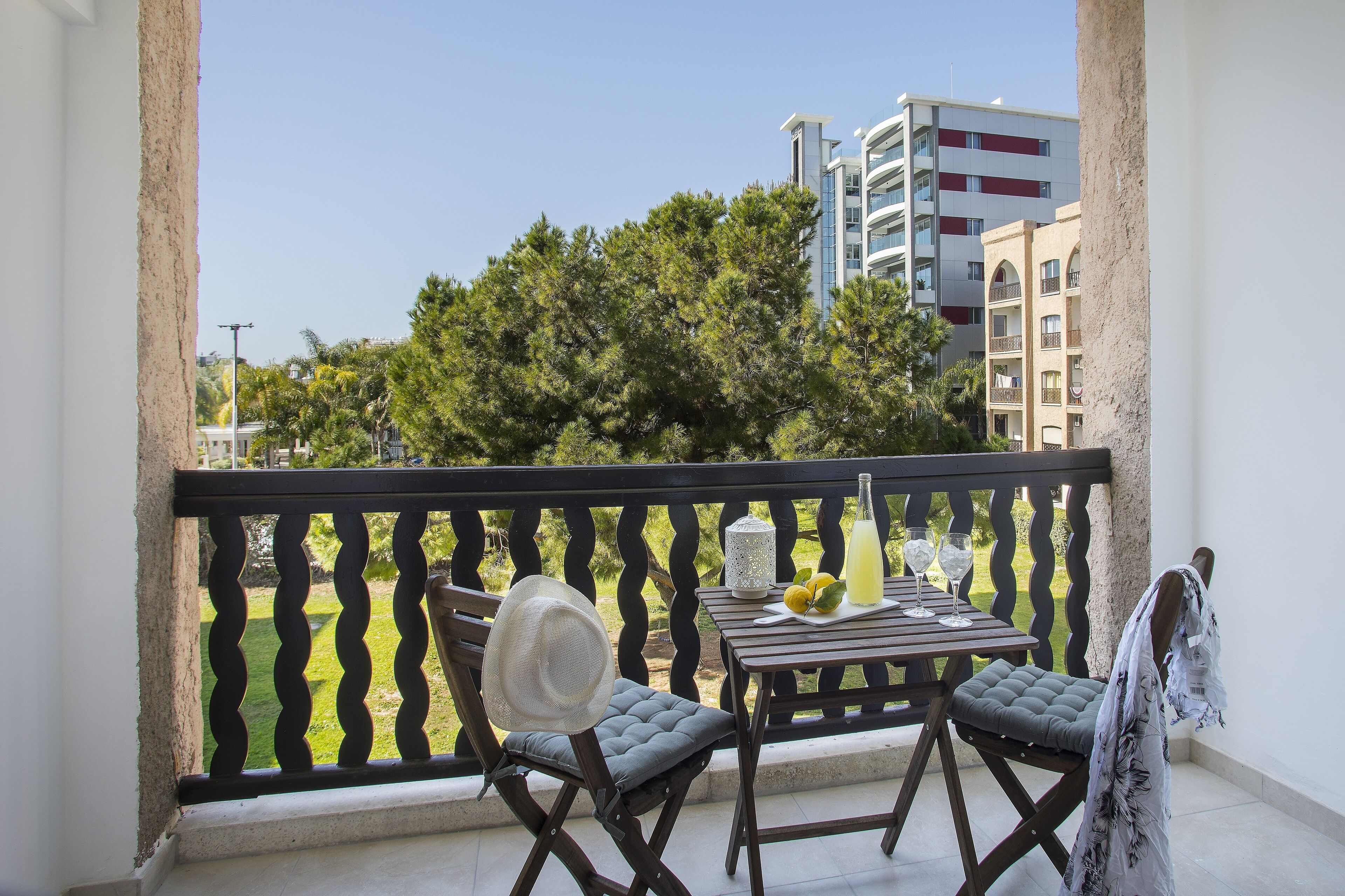 Ein Balkon mit Tisch, Stühlen und einer Getränkflasche.