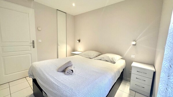 Una camera da letto con un letto, comodini, un armadio e un tavolino di fianco al letto.