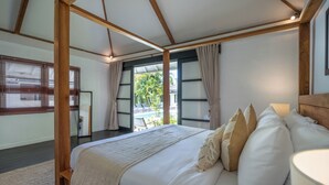A bedroom with a large bed, wooden beams, a view of a pool, and a balcony. - The Aryana Estate (Seminyak)