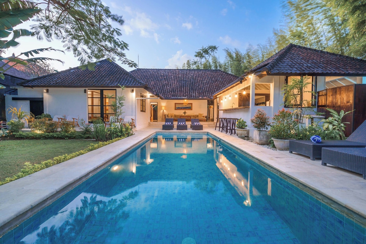 A two-story house with a swimming pool in the center.