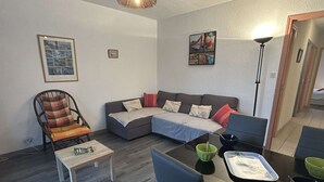 Una sala moderna con sofá, sillón, mesa de comedor y sillas.