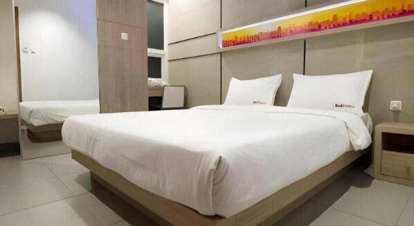 Une chambre d’hôtel moderne avec un grand lit, un lit plus petit et un bureau.