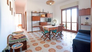 A cozy living room with a dining area, a sofa, a TV, and a bookshelf. - Appartamento Calipso (Santa Croce Camerina)
