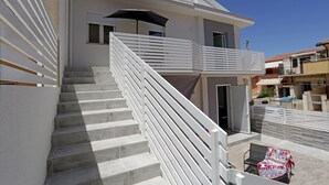Un edificio moderno de dos pisos con escaleras y un balcón.