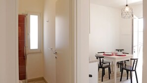 Una cocina moderna con comedor, armarios blancos y horno empotrado.