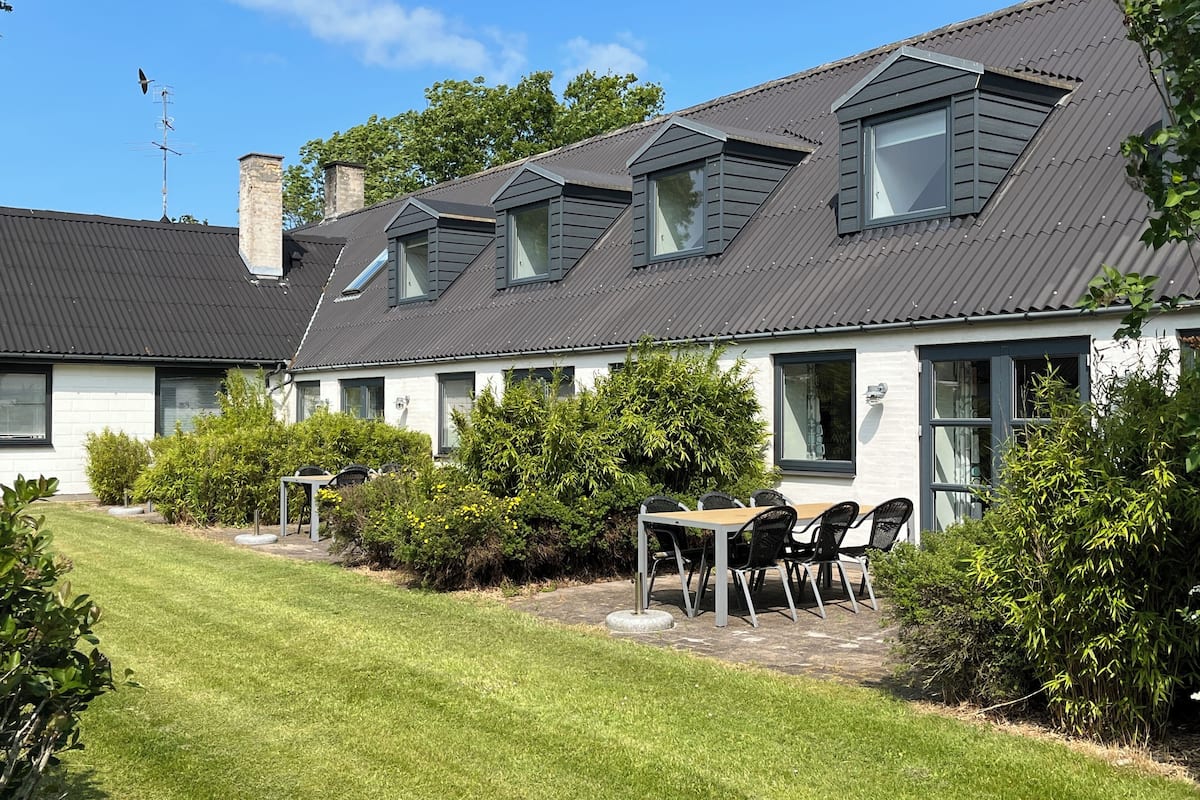 A modern house with a sloped roof, multiple windows, and a well-maintained lawn.