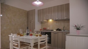 Una cocina moderna con una mesa de comedor y sillas, estufa y fregadero.