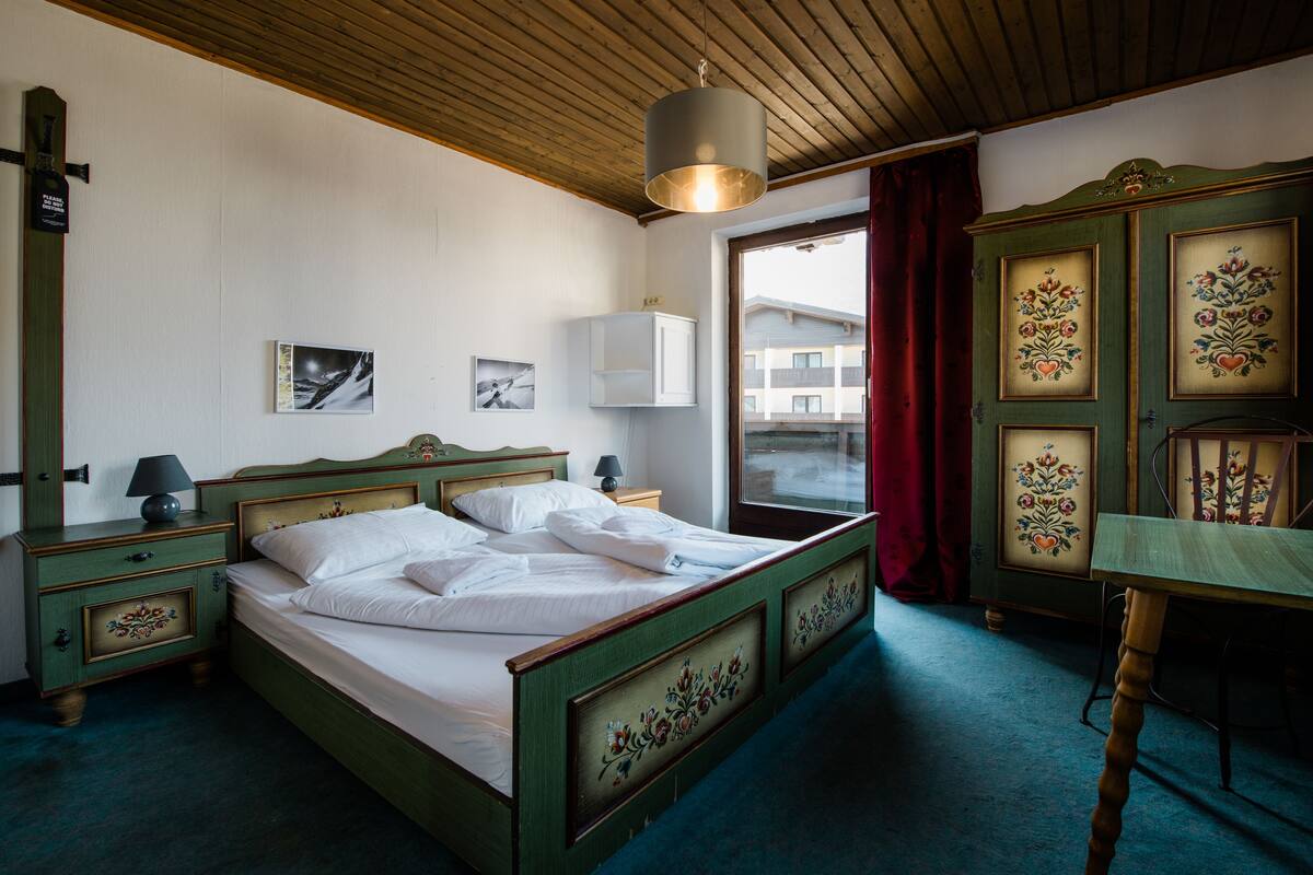 Una stanza con un letto, un comodino, un tavolo e un armadio.