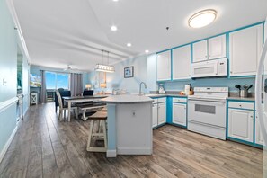 Enjoy cooking in this well-lit kitchen with a central island, sink, and oven and microwave.