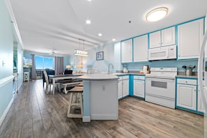 Enjoy cooking in this well-lit kitchen with a central island, sink, and oven and microwave.