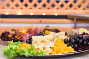 Un plat amb formatges diversos, fruita i verdura.