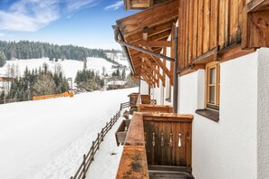 A wooden building with a balcony overlooking a snowy landscape. - Heart Hotel Widmoos (Wagrain)