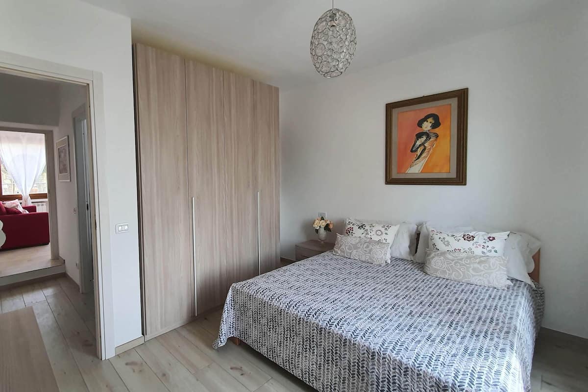 Una camera da letto con un letto, un armadio e un quadro appeso al muro.