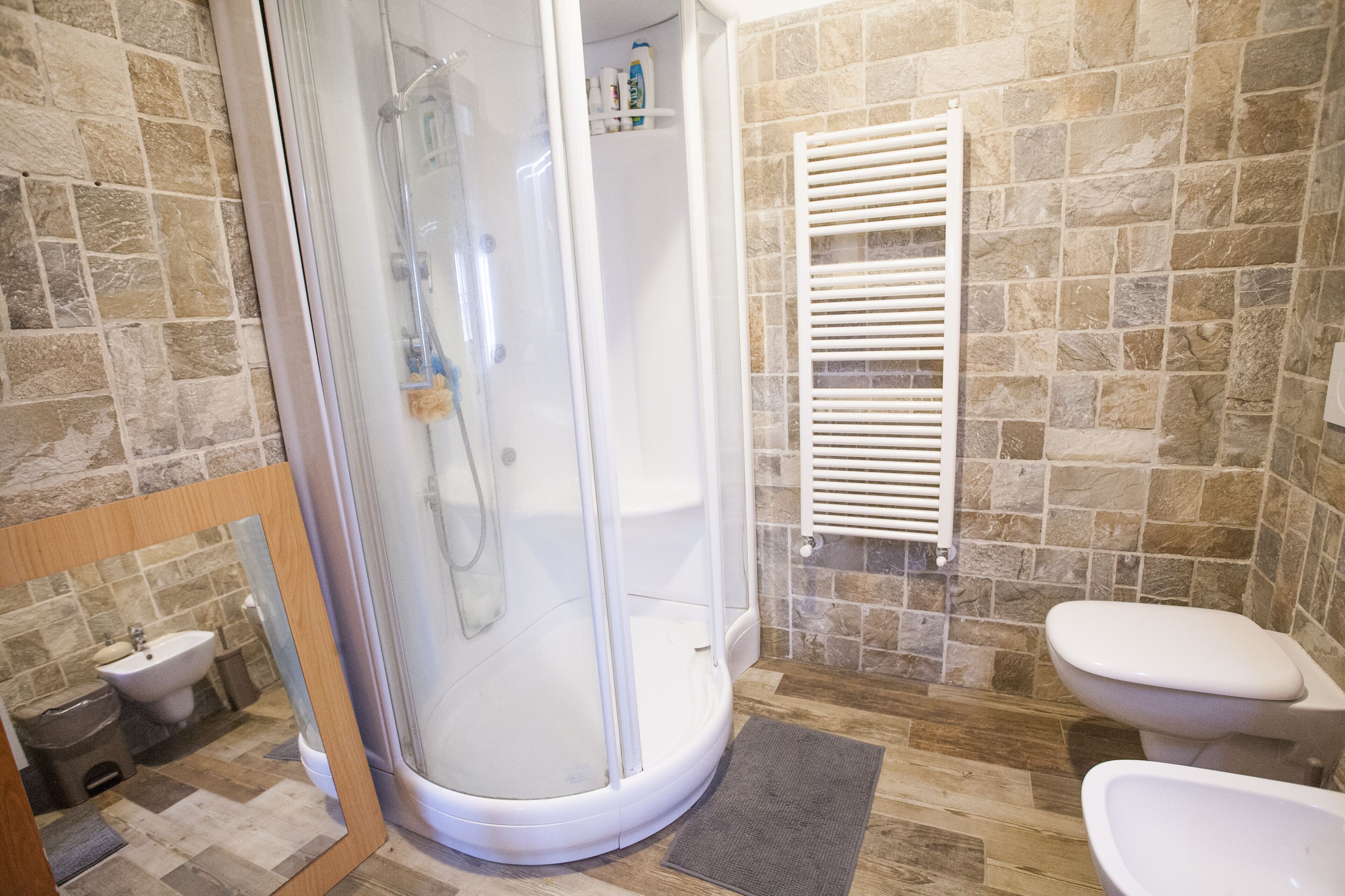 A bathroom with a glass-enclosed shower, a toilet, and a bidet.