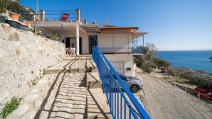 A coastal property with a stone staircase leading to a balcony overlooking the sea. - Casa Fetovaia (Campo nell'Elba)