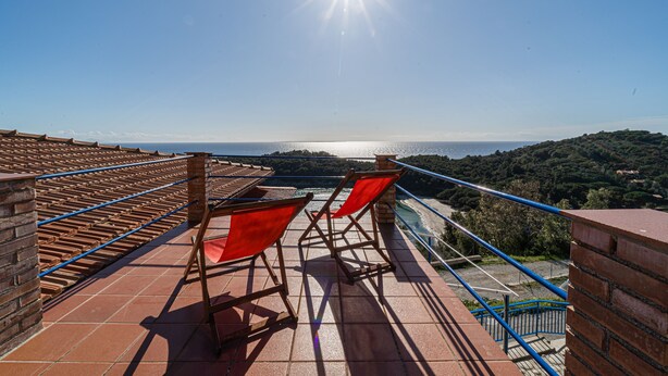 A terrace with red chairs and a view of the sea. - Casa Fetovaia (Campo nell'Elba)