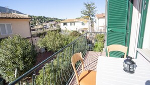 Un balcon avec une table, des chaises et une lanterne.