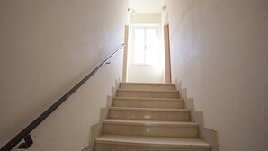 Un escalier avec une rampe menant à une porte située en haut.