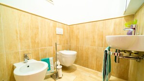 A bathroom with a bidet, a sink, and a toilet. - Monolocale Nanni (Portoferraio)