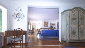 A spacious room with a wooden desk, a blue sofa, and a decorative cabinet. - Villa Il Leccio sul Mare (Portoferraio)