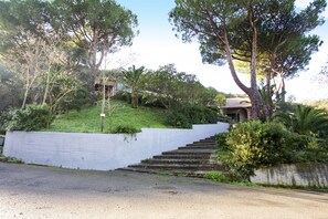 A set of outdoor stone steps leading up to a building with a dome roof, surrounded by lush greenery and trees. - Appartamenti Home 75 (Portoferraio)
