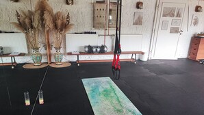 A room with a black rubber mat, a yoga mat, a camera, and two vases with dried plants. - Vacation on the pony farm (Priborn)