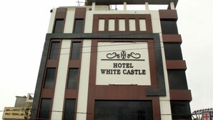 Un hotel llamado "White Castle" con un diseño moderno, que presenta un letrero llamativo y una fachada estructurada.