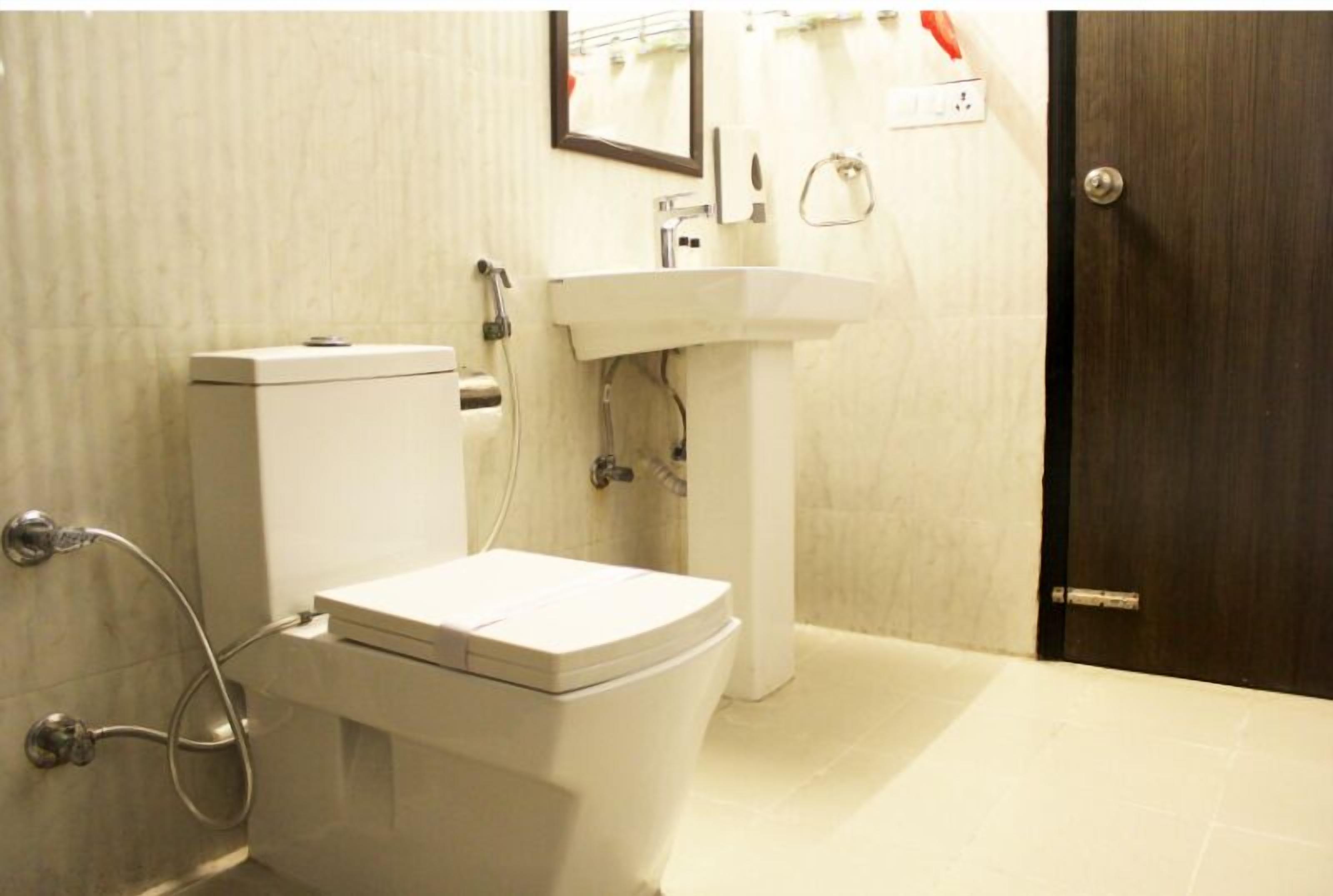 A bathroom with a toilet, sink, and shower.