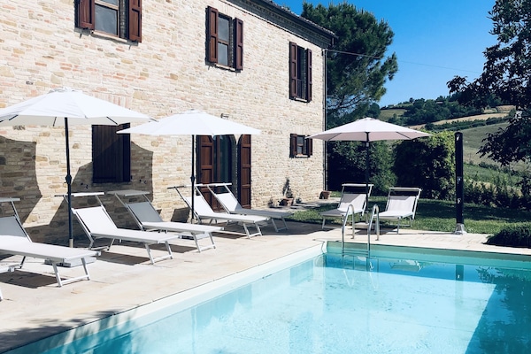 Una piscina al aire libre de temporada, sombrillas, tumbonas