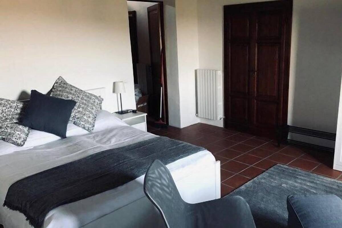 Une chambre à coucher avec un lit, une table de chevet, une lampe et une armoire.