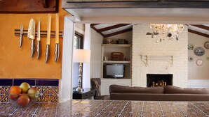 Een gezellige woonkamer met een open haard, een televisie en een bank.
