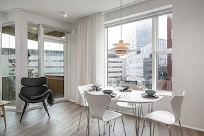 Enjoy meals with a city view from this dining area featuring a round table for four and large windows.