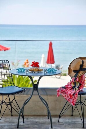 A balcony with a table set for two, overlooking the sea. - Elimia Suites & Studios (Sitia)