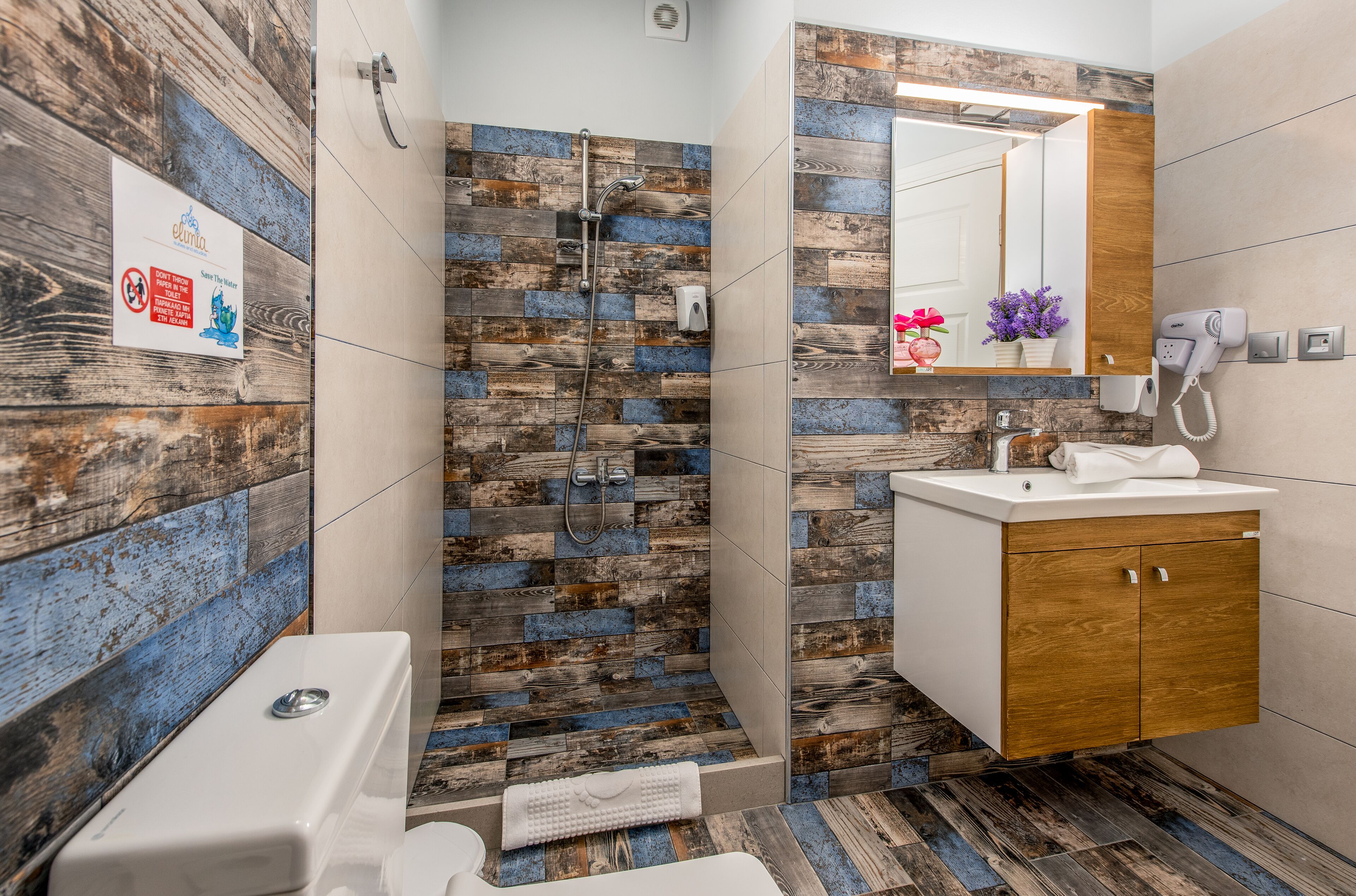 A bathroom with a shower, a sink, and a mirror.
