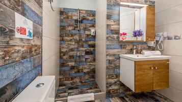 A bathroom with a shower, a sink, and a mirror.