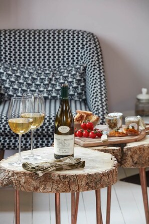 Une bouteille de vin, deux verres et une table en bois avec des plats.