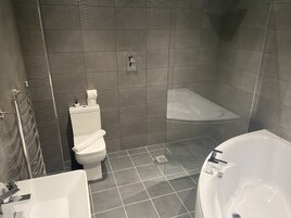 Un baño con inodoro, ducha y bañera.