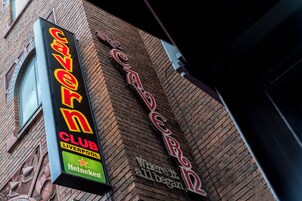 Un edificio de ladrillo con un letrero de neón que dice 'Cavern Club Liverpool' y un letrero más pequeño que indica 'Donde todo comenzó'.